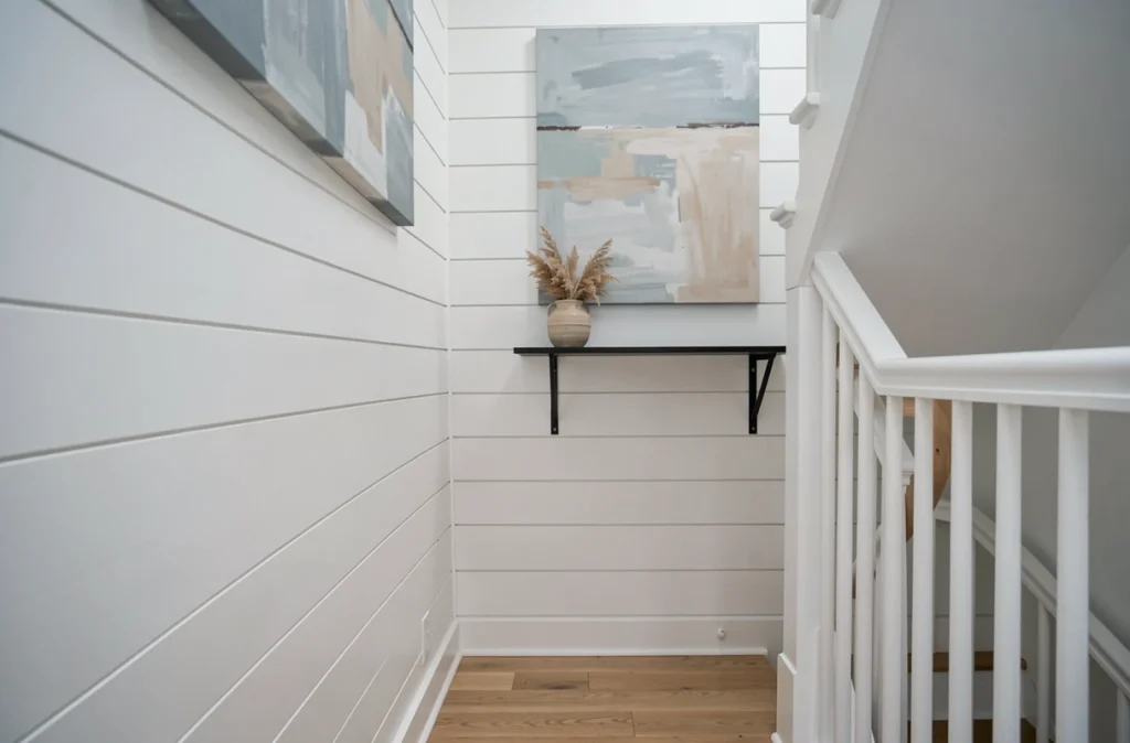 Cage d'escalier scandinave avec mur en shiplap blanc, tableau minimaliste bleu poudre et herbes de la pampa séchées