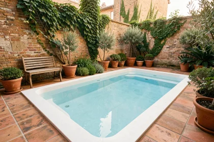 Mini-piscine compacte installée dans une petite cour urbaine avec carrelage en terre cuite et mur en brique végétalisé